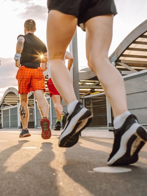 Drei Menschen joggen im Abendlicht durch die Stadt