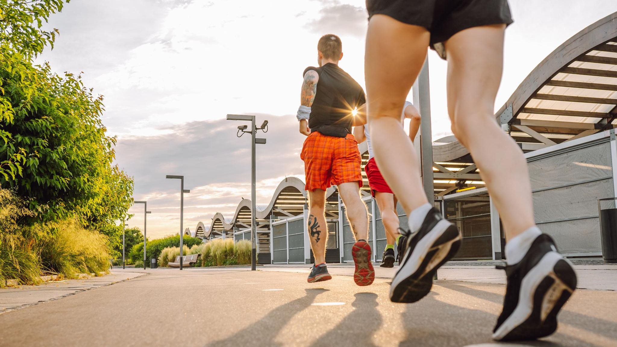 Drei Menschen joggen im Abendlicht durch die Stadt
