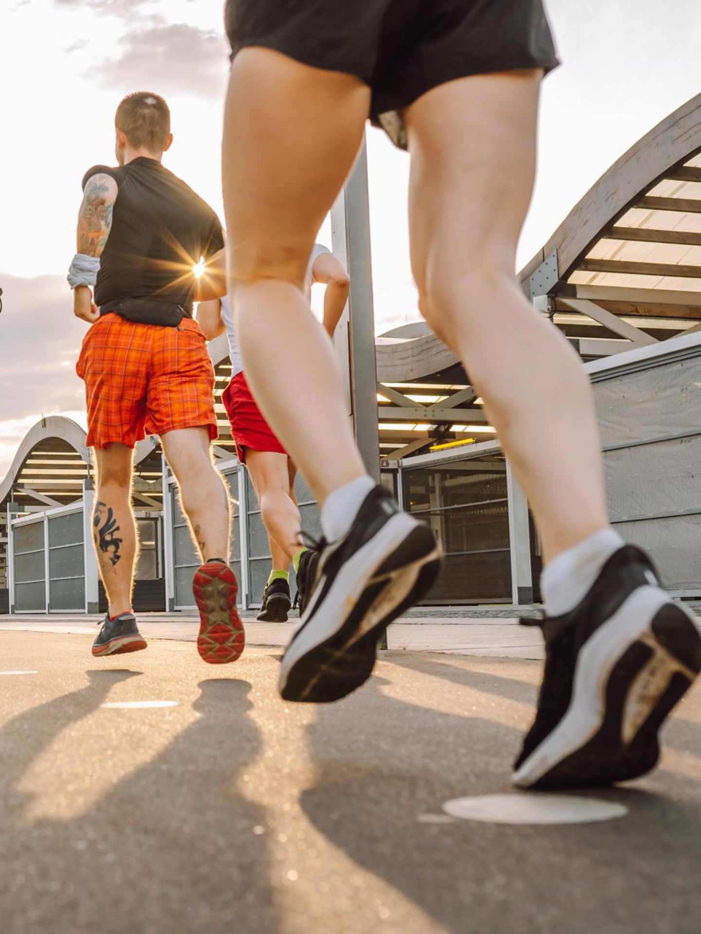 Drei Menschen joggen im Abendlicht durch die Stadt