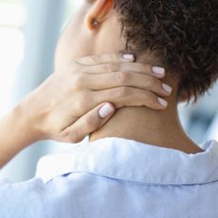 Frau knetet den Nacken wegen Verspannungen