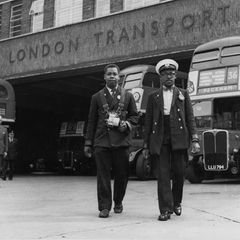 Ein Schaffner und ein Ticketkontrolleur stehen vor einem Londoner Doppeldeckerbus, Schwarz-Weiß-Aufnahme von 1957