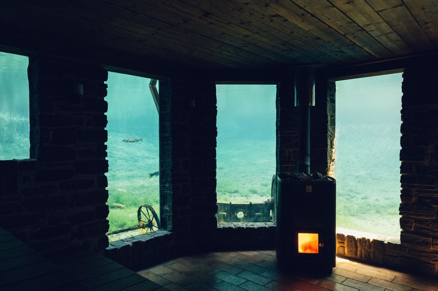 Inmitten des schwedischen Weinguts Ästad Vingård lädt eine Unterwassersauna zum Schwitzen im See ein. Durch die Fenster bietet sich pures Naturkino: Gäste beobachten flinke Regenbogenforellen und kleine Krebse, die über den sandigen Grund krabbeln. Danach lockt ein Sprung in den klaren Quellwasserteich. Und keine Sorge: Auch oberhalb der Wasseroberfläche gibt es hier Saunas und Bäder, die zum Aufwärmen und Entspannen einladen. Dann fällt der Blick ins Grüne, während das warme Holzinterieur mit seinen fließenden Linien an die Wellen im See erinnert.