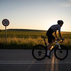Radfahrende Person auf einem Feldweg