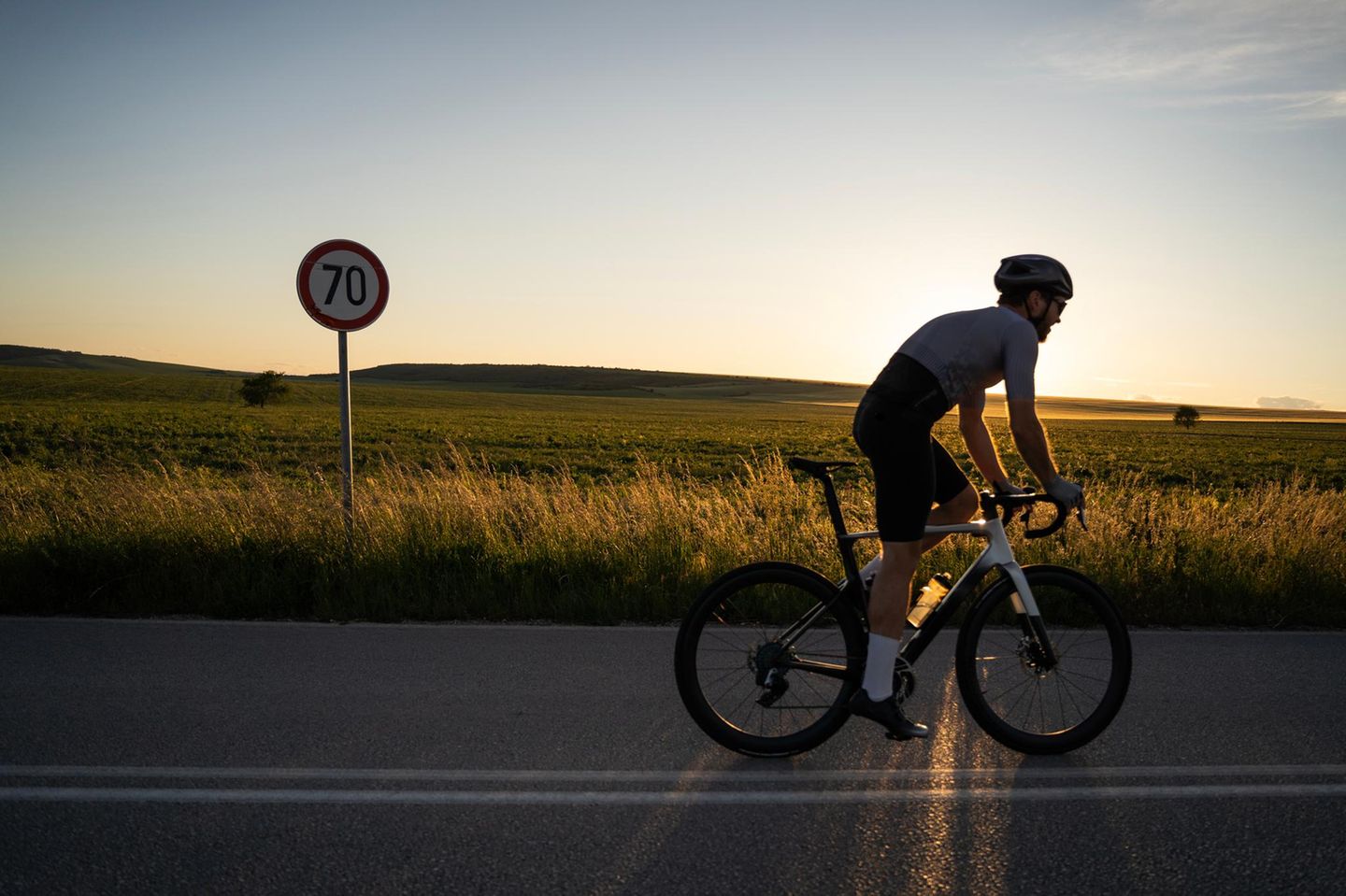 Radfahrende Person auf einem Feldweg