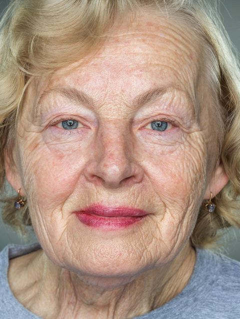 Nahaufnahme einer älteren Frau mit faltigem Gesicht vor grauem Hintergrund