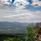 Wanderer auf dem Gipfelplateau Orensfels, dahinter hügelige Landschaft, Himmel mit Wolken