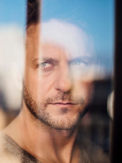 Ein Mann der ernst durch eine Glasscheibe schaut