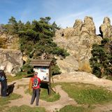 Felsgruppe Hamburger Wappen, davor zwei Wandernde vor Schild