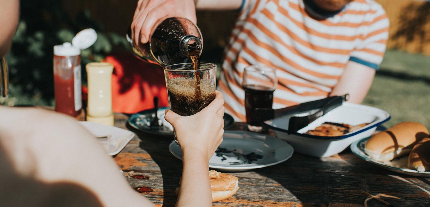 Ein Glas wird mit Cola gefüllt
