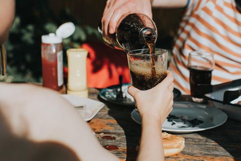 Ein Glas wird mit Cola gefüllt