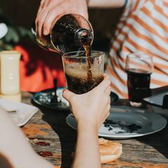 Ein Glas wird mit Cola gefüllt