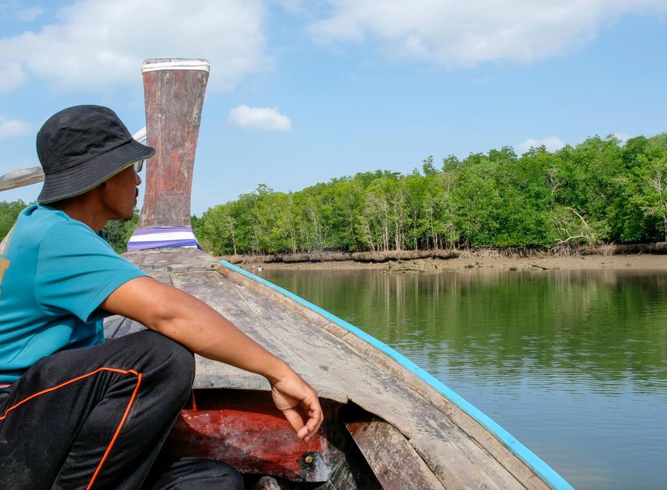 Mann auf Holzboot an Andamanensee
