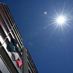 Eine Gebäudefassade und die strahlende Sonne