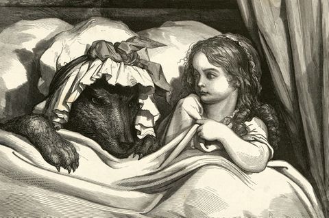 Mädchen liegt mit einem als Großmutter verkleideten Wolf im Bett