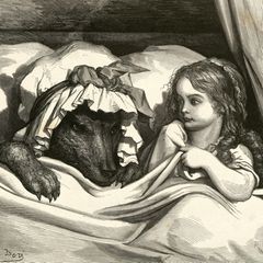 Mädchen liegt mit einem als Großmutter verkleideten Wolf im Bett