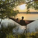 Eine Person in einer Hängematte am Ufer