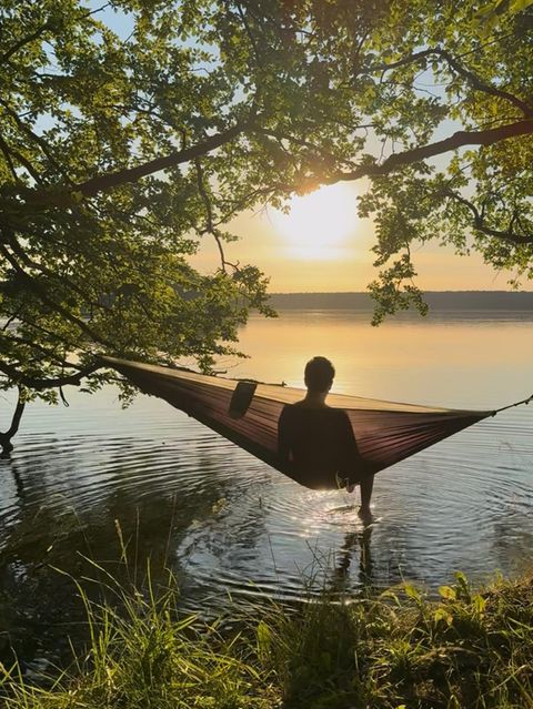 Eine Person in einer Hängematte am Ufer