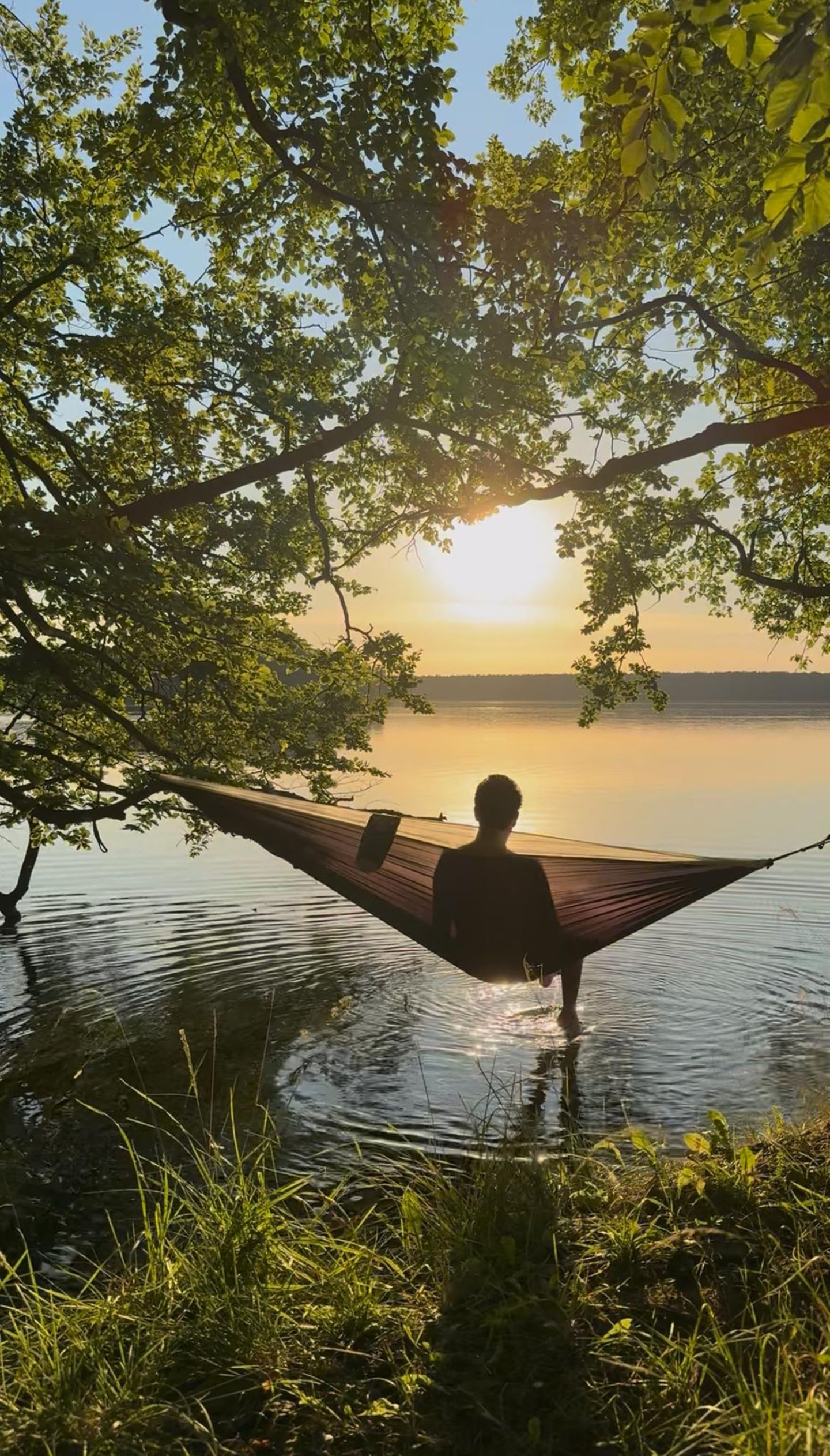 Eine Person in einer Hängematte am Ufer