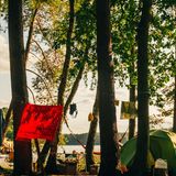 Zwischen den Bäumen spannen sich Hängematten und Wäscheleinen, bunte Zelte und Picknickdecken profitieren hier vom Schatten, während vorn der Labussee im Sonnenschein glitzert. In dessen nördlicher Bucht laden Bibertours zum Paddeln und geselligen Campen im Kiefernwald ein. Zelt vergessen? Kein Problem, ab ins Floß- oder Zelthotel. Verpflegung in Bioqualität und Campingbedarf gibt es an der Rezeption. Auf den See geht es mit geliehenem Kanu oder SUP, alternativ bringt auch eine Floßtour Spaß. Vom Zeltwald führen zwei Stege ins Wasser. Hier trifft man sich abends zum Sonnenuntergang, mit einem Teller Nudeln oder einem Buch auf dem Schoß wird es so richtig gemütlich. Danach warten Stockbrot, Sterne und Geschichten an der Feuerschale. 