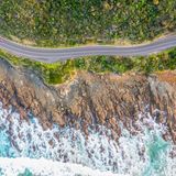 Straße Great Ocean Road zwischen grüner Landschaft, Felsen und Meer