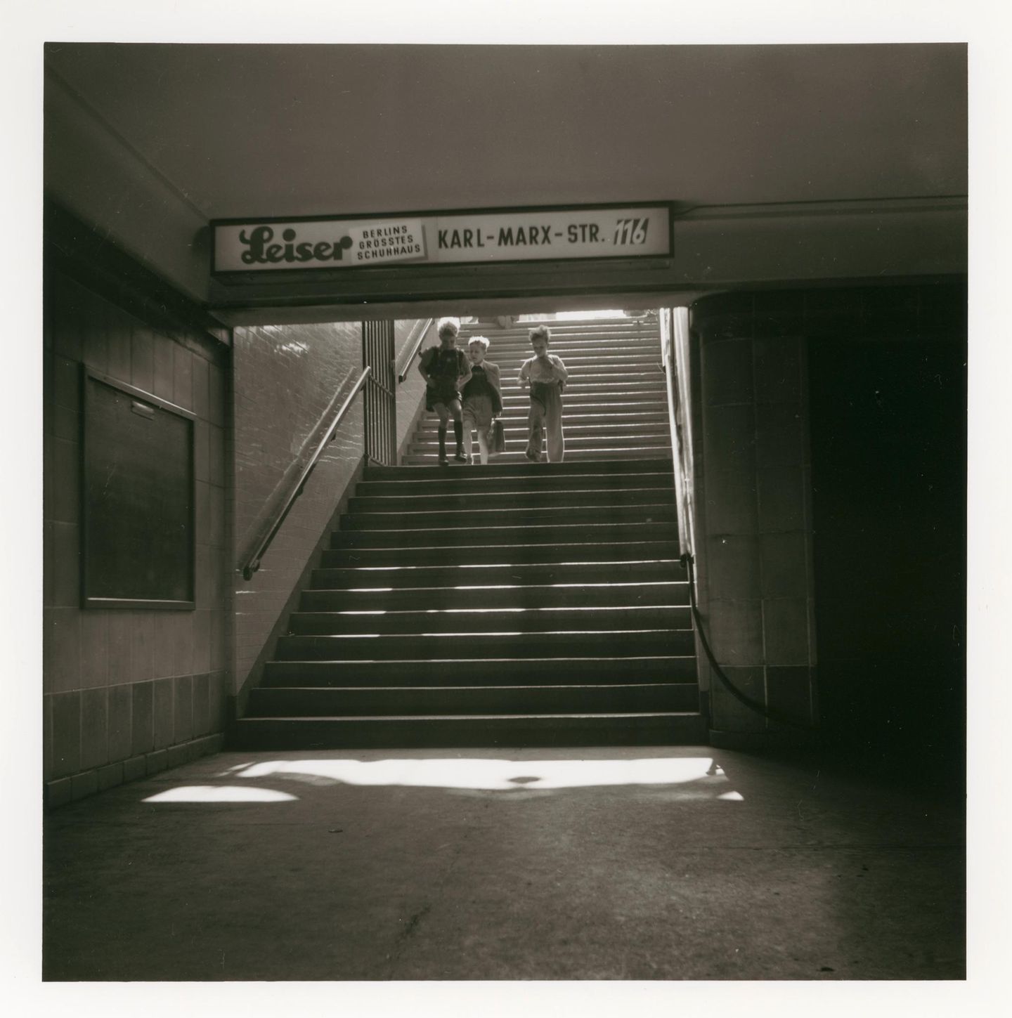 Kinder am U-Bahneingang gehen die Treppe herunter