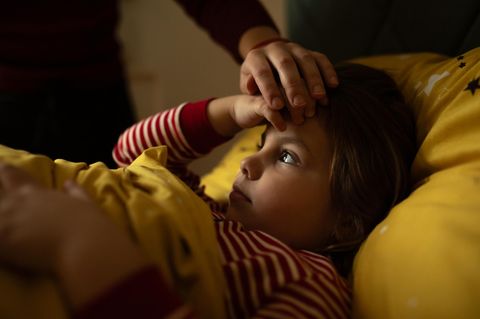 Eine Mutter hält ihre Hand auf die Stirn ihrer Tochter