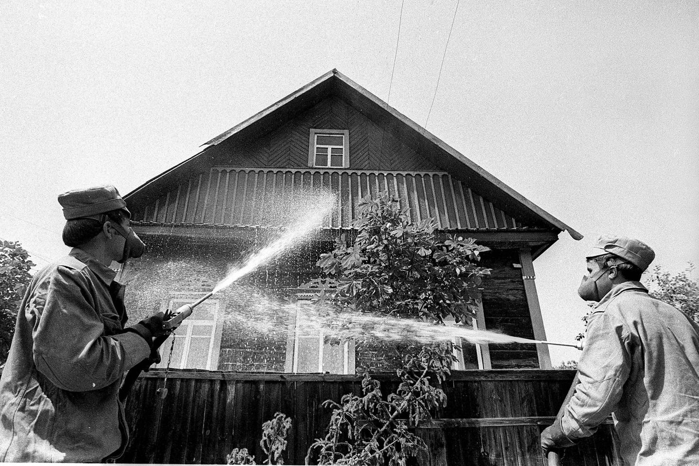 Männer dekontaminieren ein Haus mit Wasser