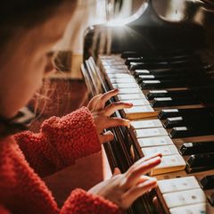 Ein Mädchen übt am Klavier