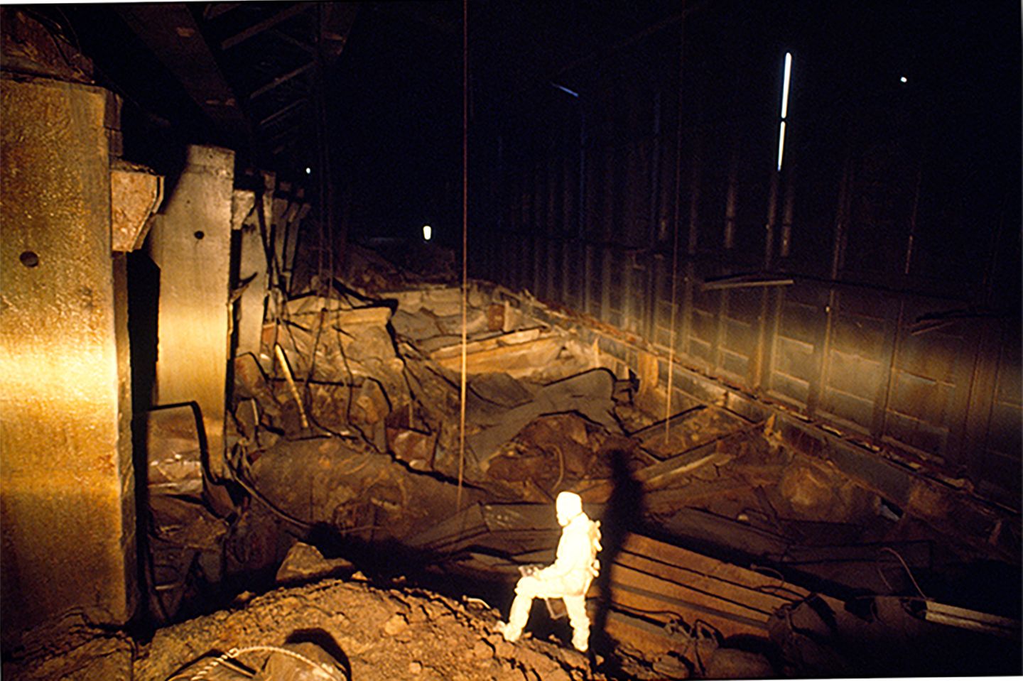 Ein Mann in Schutzkleidung wird in einem Reaktorraum angestrahlt