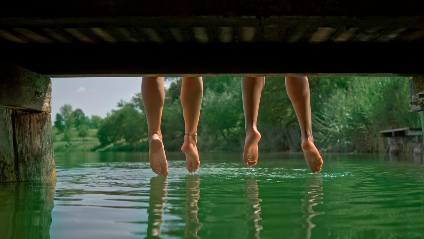 Baumelnde Füße an einem See