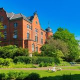 Rote Backsteinfassade, umgeben von üppigem Grün: Das Elisabeth-Anna-Palais blickt auf den Schlossteich mit seinen Gänsen. Es liegt am Rand des weitläufigen Schlossgartens im Herzen Oldenburgs. Zusammen mit den Wallanlagen und dem Botanischen Garten zählt der historische Park zu den schönsten Grünflächen der Stadt. Baumriesen, Blumenbeete, verschlungene Wege und Bachläufe laden hier zum Verweilen ein.