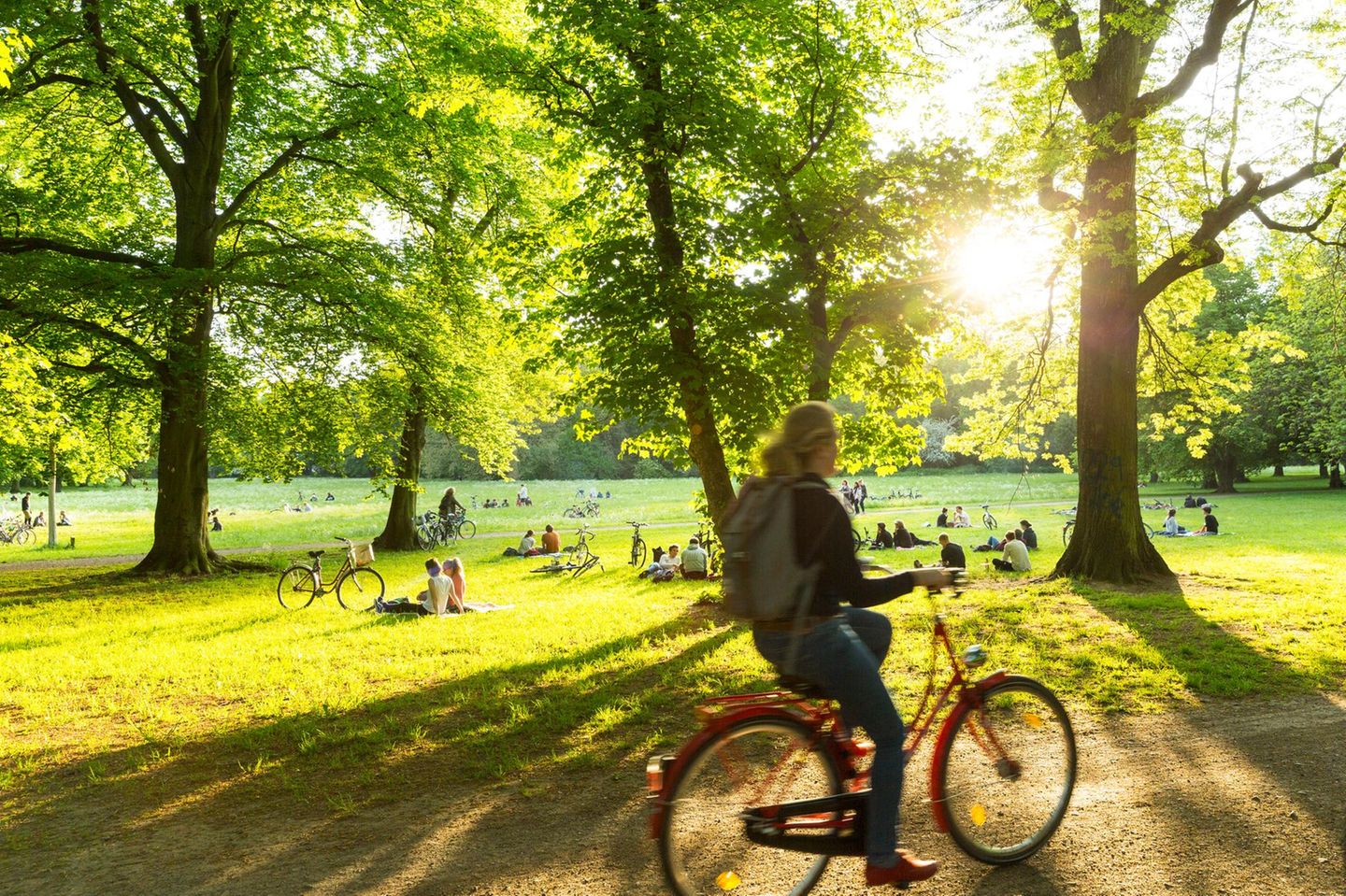 Frau fährt durch den Clara-Zetkin-Park in Leipzig mit dem Rad