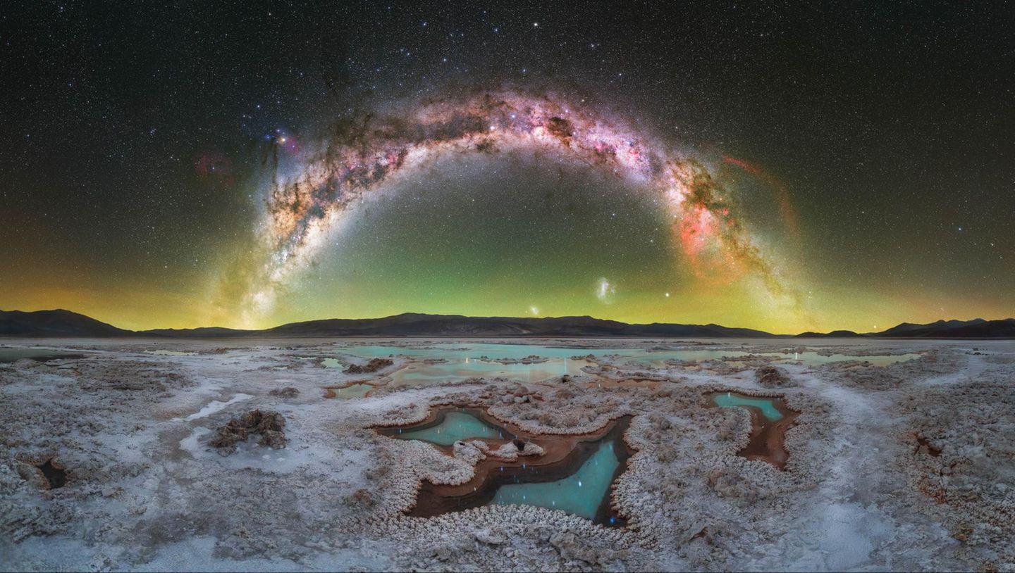 Tief in die argentinische Puna drang der Fotograf Daniel Viñé Garcia vor. Die Hochwüste liegt mehr als 3.500 Meter über dem Meeresspiegel. Dort, weit entfernt von jeglicher Lichtverschmutzung, inmitten der minimalistischen Landschaft einer Salzebene, offenbarte sich ihm ein Himmelsbogen, auf dem links das Zentrum unserer Galaxie sieht und rechts den rötlichen Gum-Nebel.