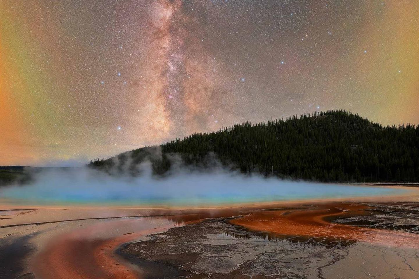 Aus der Erde steigt warmer Dampf, am Himmel funkeln die Sterne: Dass er besondere Momente festhält, wusste Baillie Farley, als er die Grand Prismatic Spring fotografierte, eine riesige Thermalquelle im Yellowstone-Nationalpark. "Der sich ständig verändernde Dunst verwandelte die Szenerie von einem Moment zum nächsten", sagt er. "Kurzzeitig gab er den Blick auf die Sterne frei, verhüllte sie jedoch sofort wieder."  