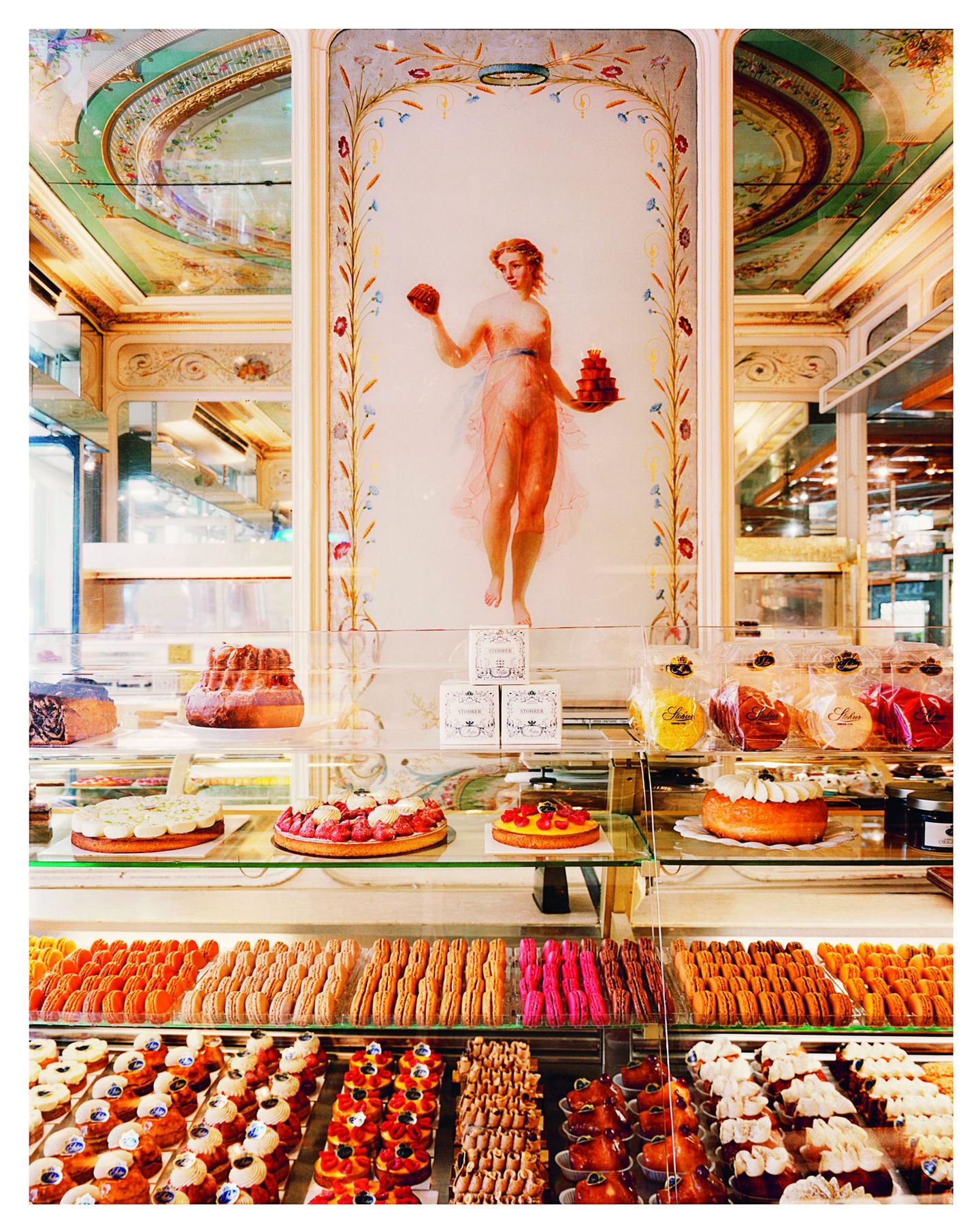 Wandbild einer Frau, davor Kuchentheke