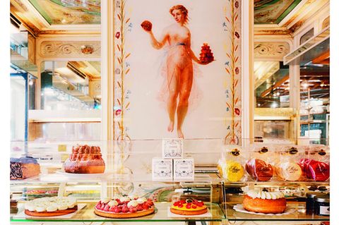 Wandbild einer Frau, davor Kuchentheke