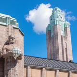 Turm und Statuen am Hauptbahnhof Helsinki, im Hintergrund blauer Himmel mit Wolke