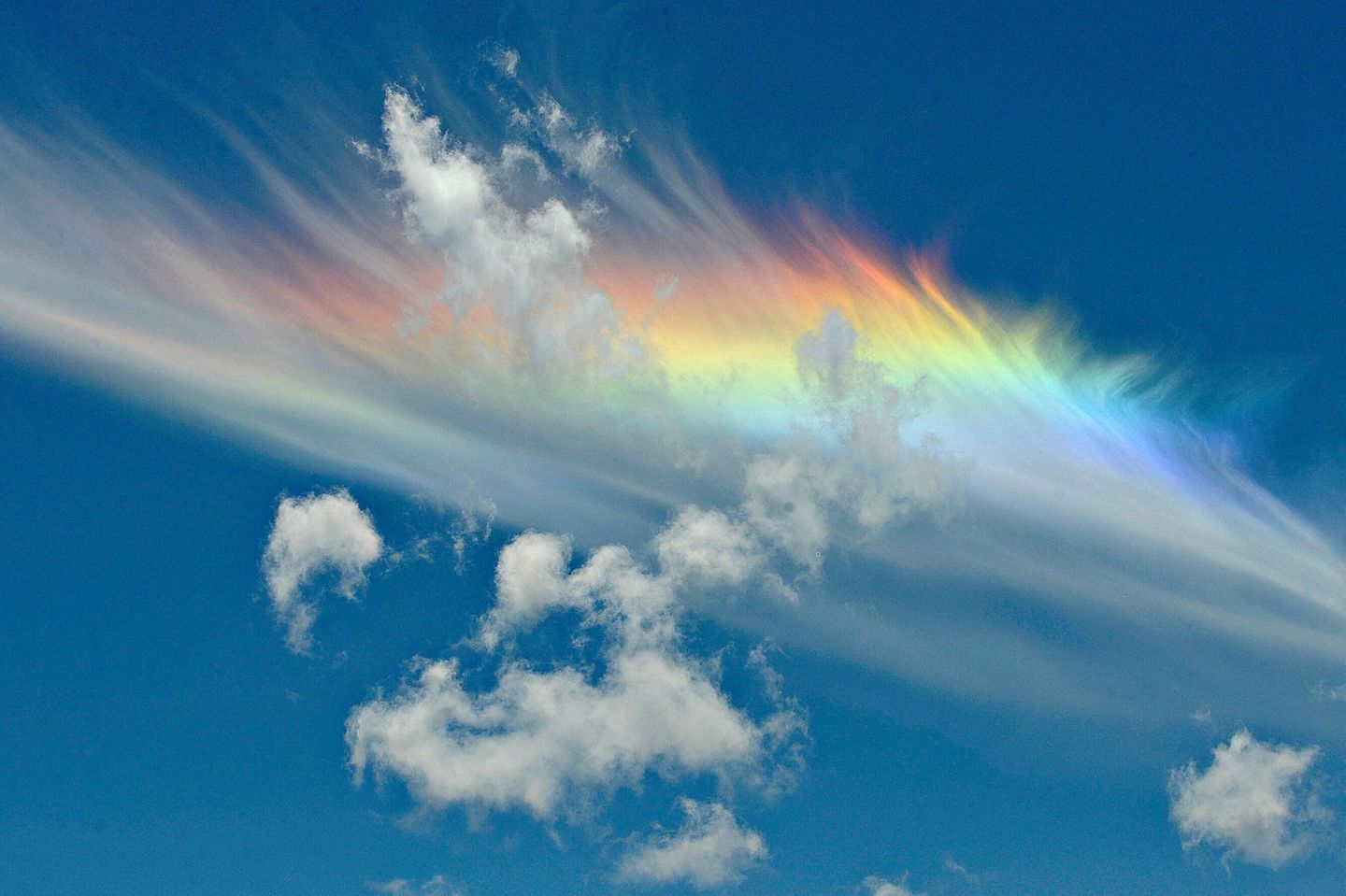 Der Name des Feuerregenbogens führt in die Irre. Hier brechen keine Wassertropfen das Licht, sondern Eiskristalle in hohen Feder- und Schleierwolken. Um den Effekt zu erzeugen, müssen die sechseckigen Plättchen nahezu waagerecht in der Luft schweben. Dann fächern sie seitlich einfallendes Licht auf wie ein Prisma. Eine weitere Voraussetzung: Die Sonne muss mindestens 57,8 Grad über dem Horizont stehen. Deshalb erscheint ein Zirkumhorizontalbogen bei uns höchstens im Sommer zur Mittagszeit.