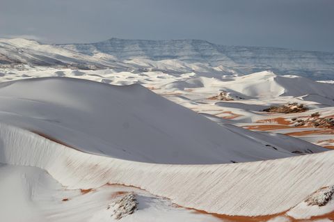 Glühende Hitze, flirrende Luft, kein Wasser weit und breit: So stellt man sich die Sahara vor. Doch gelegentlich bedeckt ein Kälteeinbruch ihre Sanddünen mit Schnee. So geschehen 2018 um die algerische Stadt Aïn Séfra, auch "Tor zur Wüste" genannt. Sie liegt gut 1000 Meter über dem Meeresspiegel. Trifft feuchte Seeluft dort auf eisige Wüstenluft, fallen Flocken. Einst galt das Phänomen als extrem selten – doch seit 2016 tritt es in der Gegend immer wieder auf.