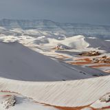 Glühende Hitze, flirrende Luft, kein Wasser weit und breit: So stellt man sich die Sahara vor. Doch gelegentlich bedeckt ein Kälteeinbruch ihre Sanddünen mit Schnee. So geschehen 2018 um die algerische Stadt Aïn Séfra, auch "Tor zur Wüste" genannt. Sie liegt gut 1000 Meter über dem Meeresspiegel. Trifft feuchte Seeluft dort auf eisige Wüstenluft, fallen Flocken. Einst galt das Phänomen als extrem selten – doch seit 2016 tritt es in der Gegend immer wieder auf.