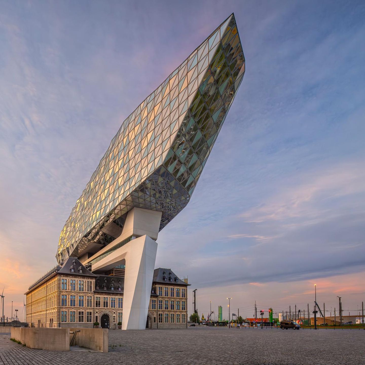 Großer Platz mit Backsteingebäude und riesigem Anbau in Form eines Diamanten