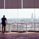 Mann blickt auf Dächer und Skyline von Antwerpen aus dem Museum Aan de Stroom