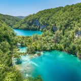 Paradiesblaue Seenlandschaft: Dieser Nationalpark ist nicht ohne Grund der älteste und größte Kroatiens. 1949 wurde das Gebiet zum Nationalpark erklärt, seit 1979 gehört es zum UNESCO-Weltnaturerbe. Die Plitvicer Seen liegen nahe der Grenze zu Bosnien-Herzegowina und unweit der kroatischen Adria. Ein Besuch lässt sich leicht mit Abstechern in die Badeorte entlang der Küste verbinden. Das Meer ist etwa eineinhalb Stunden entfernt, in die andere Richtung dauert es ungefähr genauso lange bis nach Zagreb.