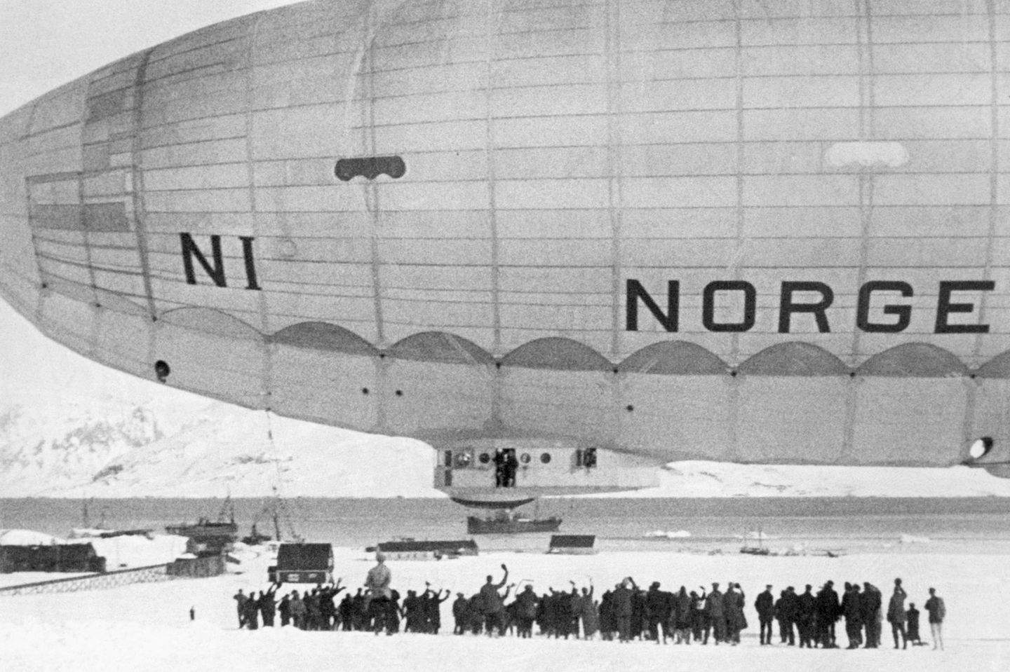 Eine Menschenmenge winkt dem startenden Luftschiff "Norge" zu.