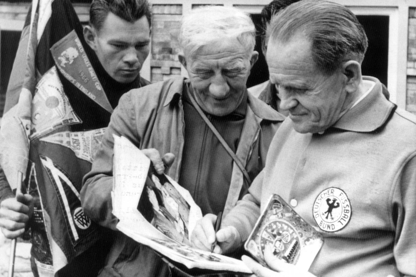 Sepp Herberger (r.) trifft während der Weltmeisterschaft 1966 im englischen Ashbourne auf zwei besondere Unterstützer: Kurt Bednarek (M.) und Manfred Pankalla (l.), waren mit dem Moped zur Weltmeisterschaft angereist. Herberger, der "Weise von der Bergstraße", hatte Deutschland mit dem "Wunder von Bern" 1954 nicht nur zum ersten WM‑Titel geführt, sondern einem vom Krieg müden Land ein neues Selbstbewusstsein gegeben. Seine Sätze – "Das Spiel dauert 90 Minuten" und "Nach dem Spiel ist vor dem Spiel" – gehören längst zum festen Repertoire deutscher Fußballweisheiten.