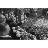 Eine begeisterte Menge füllt am 31. Juli 1966 den Frankfurter Römerberg und jubelt der deutschen Nationalmannschaft auf dem Balkon des Rathauses zu. Vorn steht Oberbürgermeister Willi Brundert, in der Mitte Uwe Seeler mit ausgestrecktem Zeigefinger, dahinter der junge Franz Beckenbauer. Erst einen Tag zuvor hatte England das WM‑Finale in Wembley nach Verlängerung mit 4:2 gewonnen – doch trotz der Niederlage feiern die Fans "ihre" Vizeweltmeister wie Sieger.