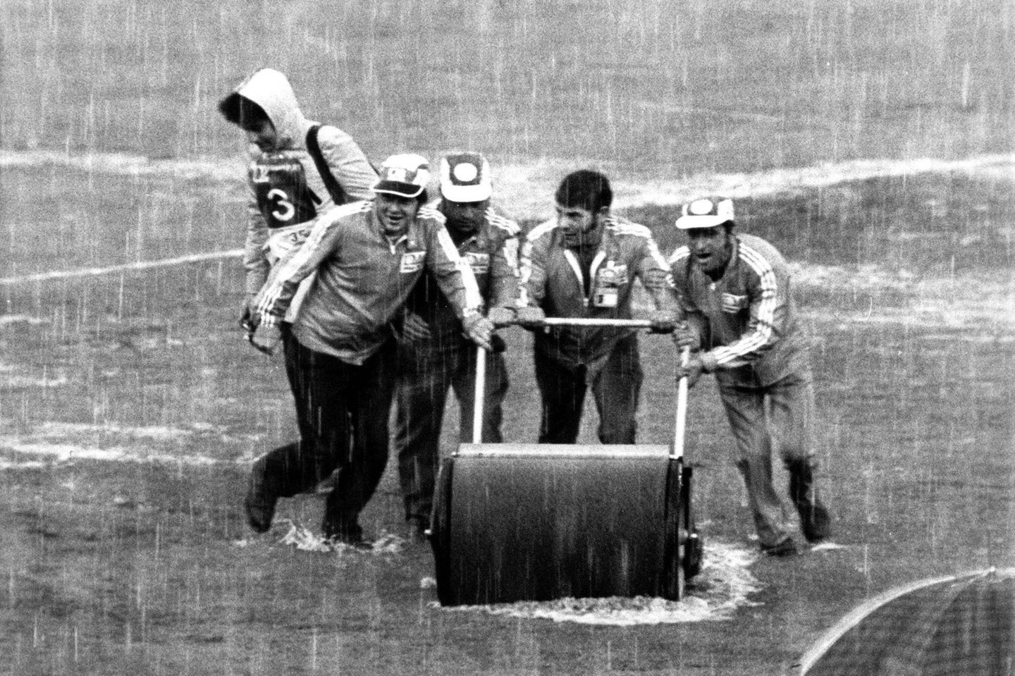 Eine halbe Stunde vor dem Anpfiff des Spiels Deutschland gegen Polen am 3. Juli 1974 steht plötzlich alles auf der Kippe. Ein Wolkenbruch verwandelt den Rasen des Frankfurter Waldstadions in eine Seenlandschaft: Stadionhelfer schieben mit schweren Walzen das Wasser vom Spielfeld, während 62.000 Zuschauer ausharren. Die Partie wird um 30 Minuten verschoben. Als der Ball endlich wieder halbwegs rollt, ist der Boden noch immer schwer und rutschig – doch am Ende sorgt ein Tor für das 1:0 und den Finaleinzug der deutschen Elf.