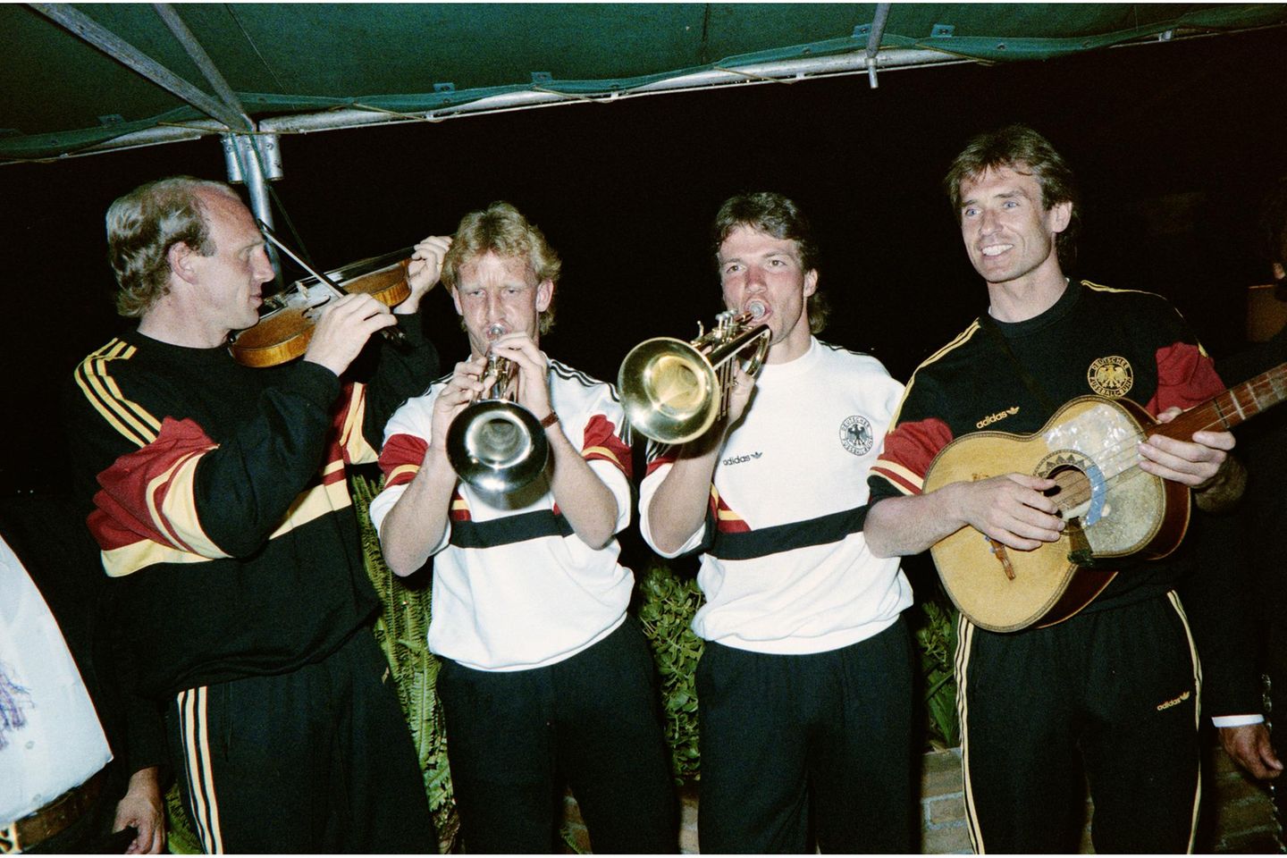 Deutschlands Fußballnationalmannschaft vertreibt sich am 25. Mai 1986 im WM-Quartier nahe dem mexikanischen Querétaro die Zeit fernab von Taktiktafeln und Trainingseinheiten: Auf der Terrasse greifen Dieter Hoeneß, Andreas Brehme, Lothar Matthäus und Norbert Eder (von links) zu Instrumenten und probieren sich als Ad-hoc-Kapelle. In jenen Tagen stellt sich die Mannschaft auf die Hitze und Höhenlage im Gastgeberland ein. Im Finale unterliegt Deutschland Argentinien mit 2:3.