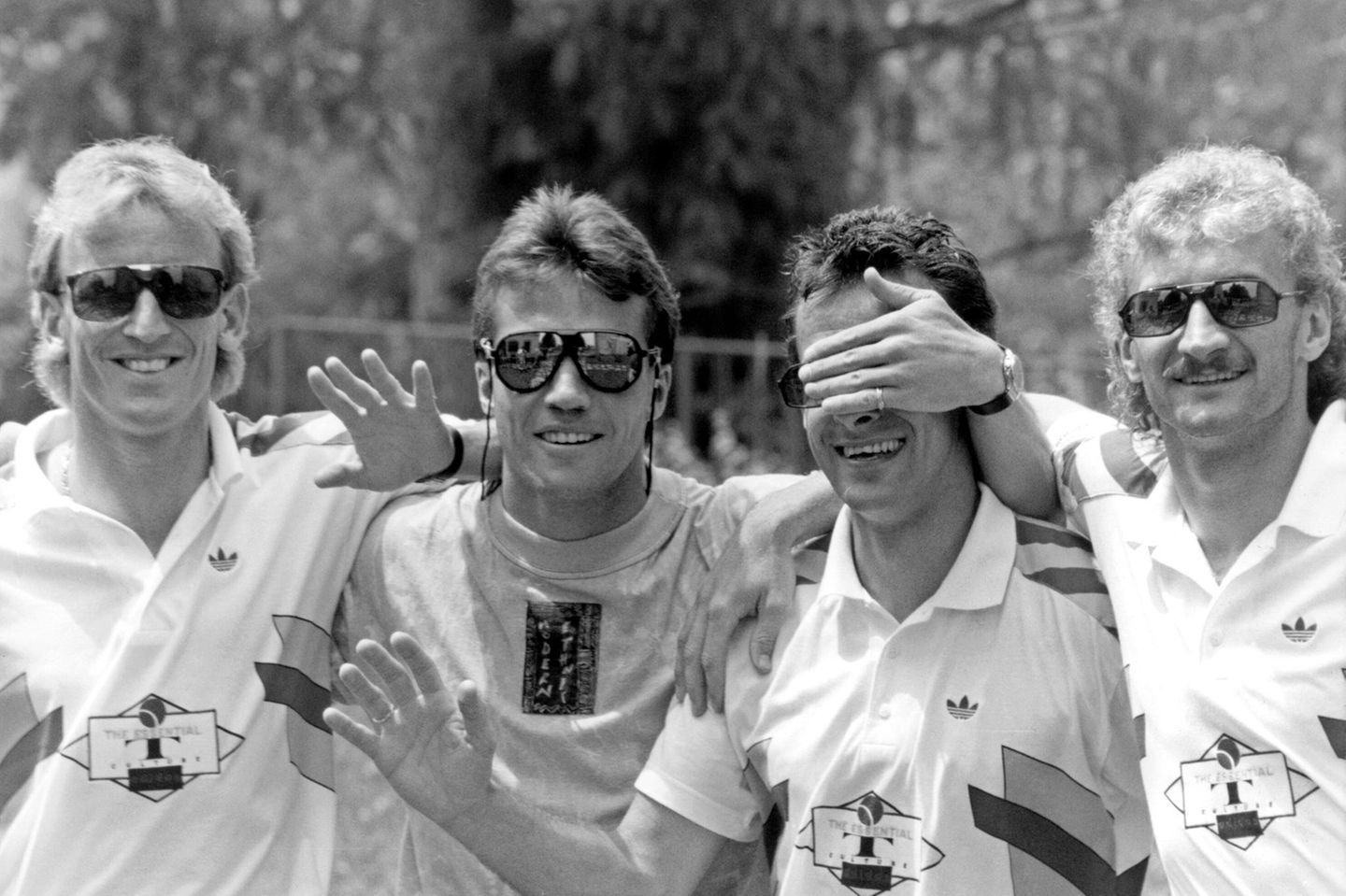 Für eine neue Kollektion Sonnenbrillen posieren am 29. Juni 1990 im italienischen Erba, dem WM-Quartier der DFB-Auswahl, vier Spieler, die längst zu Gesichtern dieser Turniermannschaft geworden sind: Andreas Brehme, Lothar Matthäus, Pierre Littbarski und Rudi Völler (von links). Die Szene erzählt auch davon, wie sehr sich der Fußball inzwischen gewandelt hat: Neben Laufwegen, Taktik und Standards gehören nun Sponsorenauftritte, Produktpräsentationen und perfekte Außendarstellung zum Alltag einer Mannschaft, die wenige Tage später in Rom den Titel gewinnen wird.