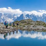 Wandergruppe vor Bergkulisse in den Alpen, im Vordergrund Wasser
